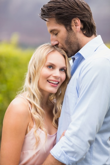 Jeune homme heureux embrassant la femme sur le front