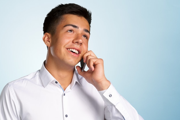 Jeune homme heureux occasionnel au téléphone