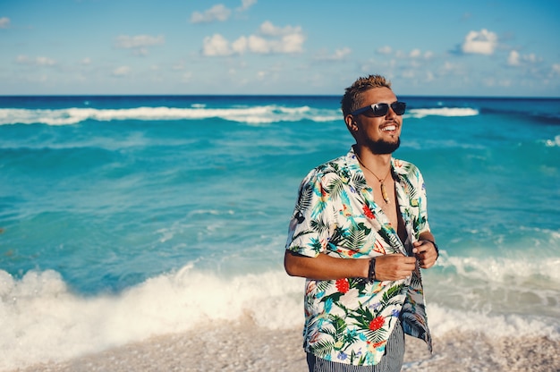 Jeune homme heureux portant une chemise hawaïenne à la mer ou au fond de l'océan