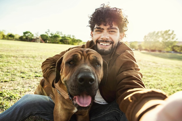 Jeune homme heureux prenant selfie avec son chien dans un parc