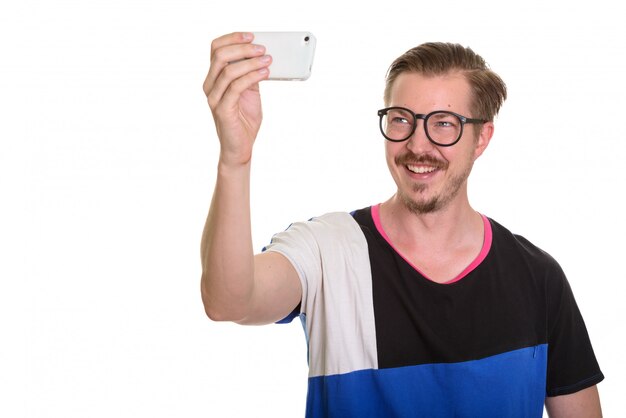 Jeune homme heureux prenant selfie avec téléphone mobile