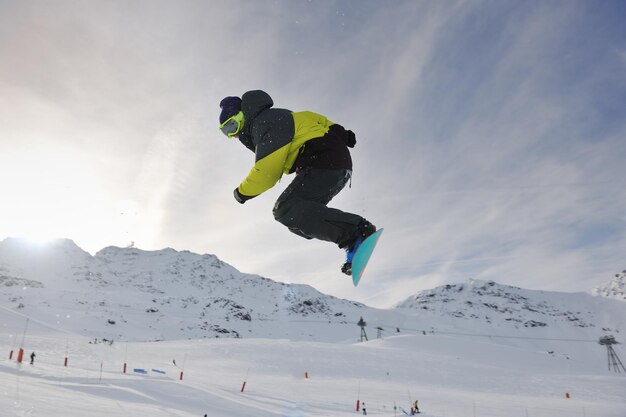 un jeune homme heureux s'amuse en hiver au sommet de la montagne