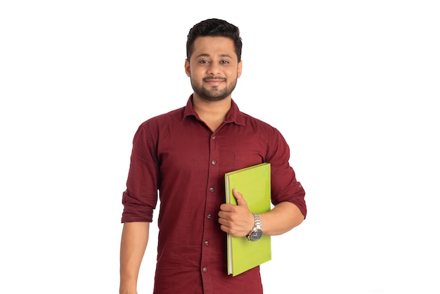 Jeune homme heureux tenant et posant avec le livre sur fond blanc