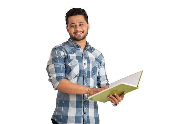 Jeune homme heureux tenant et posant avec le livre sur fond blanc