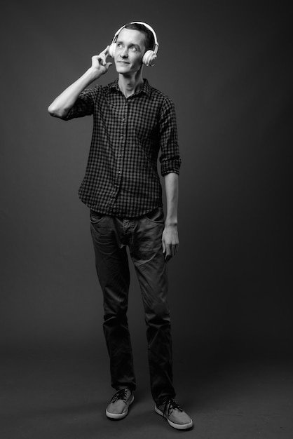 jeune homme hipster contre mur gris en noir et blanc
