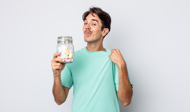 Jeune homme hispanique à l'air arrogant, réussi, positif et fier. concept de bonbons à la gelée