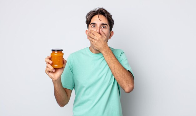 Jeune homme hispanique couvrant la bouche avec les mains avec un choc. concept de gelée de pêche