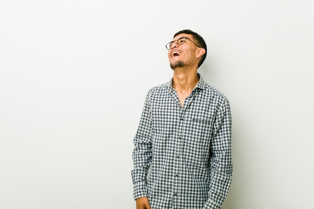 Jeune homme hispanique détendu et heureux de rire, le cou tendu montrant les dents.