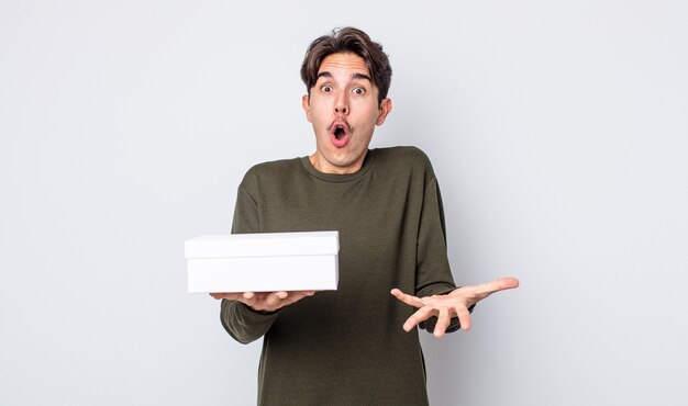 jeune homme hispanique étonné, choqué et étonné d'une incroyable surprise. concept de boîte blanche