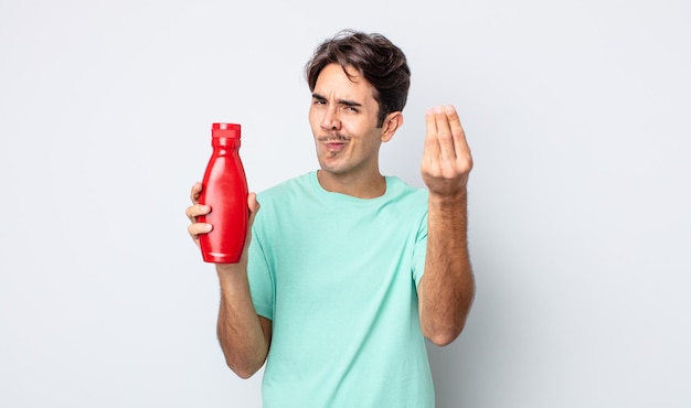 Jeune homme hispanique faisant un capice ou un geste d'argent, vous disant de payer. notion de ketchup