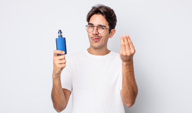 Jeune homme hispanique faisant un geste de capice ou d'argent, vous disant de payer. concept de vaporisateur de fumée