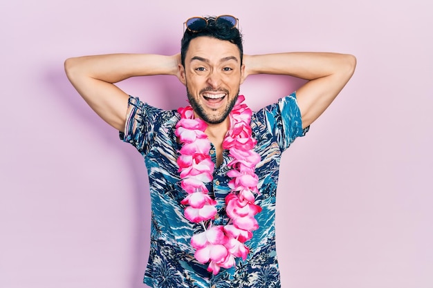 Jeune homme hispanique portant un style d'été souriant et riant fort à haute voix parce que drôle de blague folle