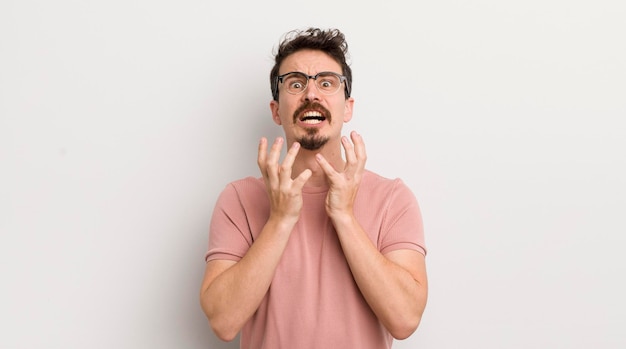 Jeune homme hispanique à la recherche désespérée et frustrée, stressée, malheureuse et agacée, criant et hurlant