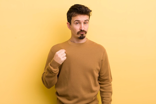 Jeune homme hispanique à la recherche de succès arrogant positif et fier pointant vers soi