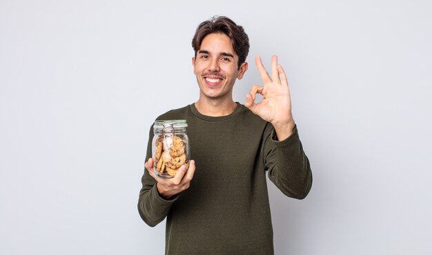 Jeune homme hispanique se sentant heureux, montrant son approbation avec un geste correct. notion de cookies