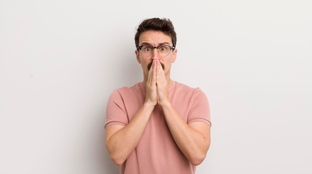 Jeune homme hispanique se sentant inquiet bouleversé et effrayé couvrant la bouche avec les mains à l'air anxieux et ayant foiré