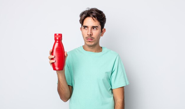 Jeune homme hispanique se sentant triste, bouleversé ou en colère et regardant sur le côté. notion de ketchup