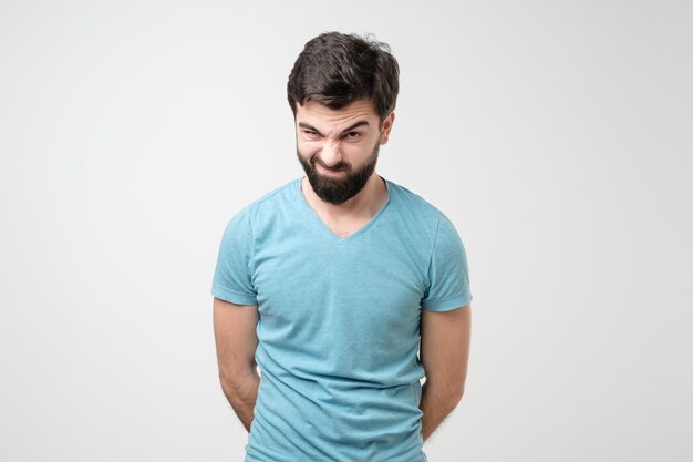 Photo jeune homme hispanique sérieux avec un sourcil levé ayant des doutes ou de la méfiance