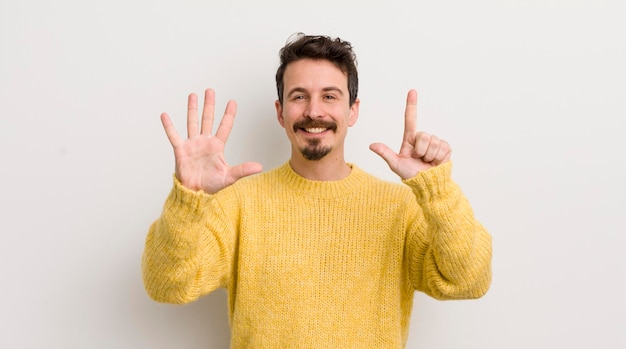 Jeune homme hispanique souriant et amical montrant le numéro sept ou septième avec la main en avant compte à rebours