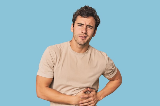 Un jeune homme hispanique en studio qui a mal au foie, à l'estomac.