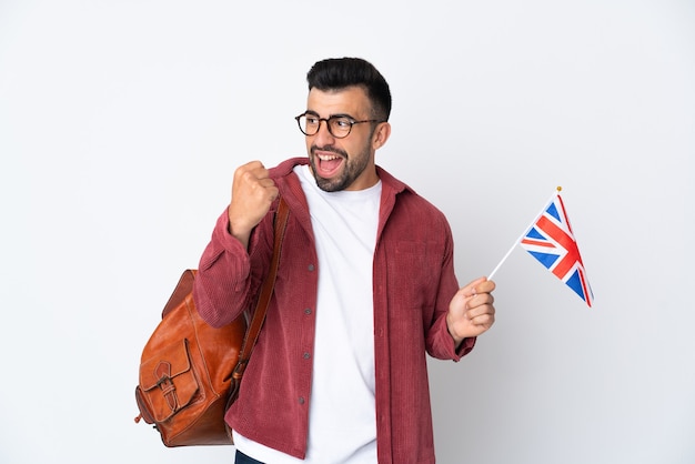 Jeune homme hispanique tenant un drapeau du Royaume-Uni célébrant une victoire