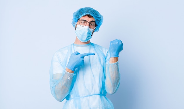 Un jeune homme impatient et en colère, montrant la montre, demandant la ponctualité, veut être à l'heure. concept de coronavirus