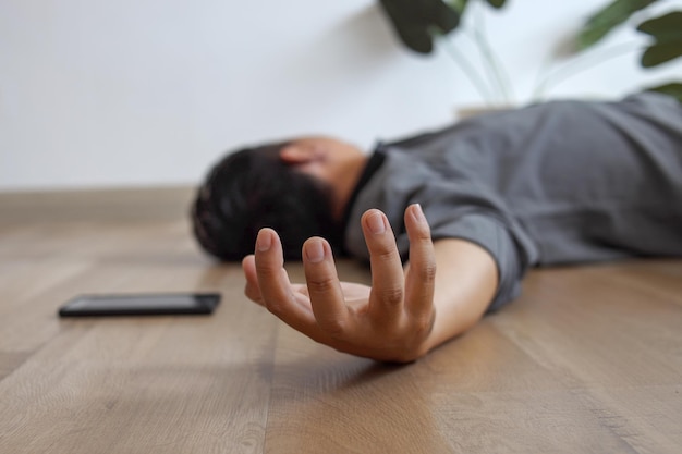 Un jeune homme inconscient allongé sur le sol avec des crises d'épilepsie à la maison se blesse chez un homme