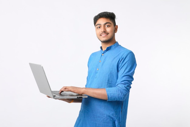 Jeune homme indien à l'aide d'ordinateur portable sur fond blanc.