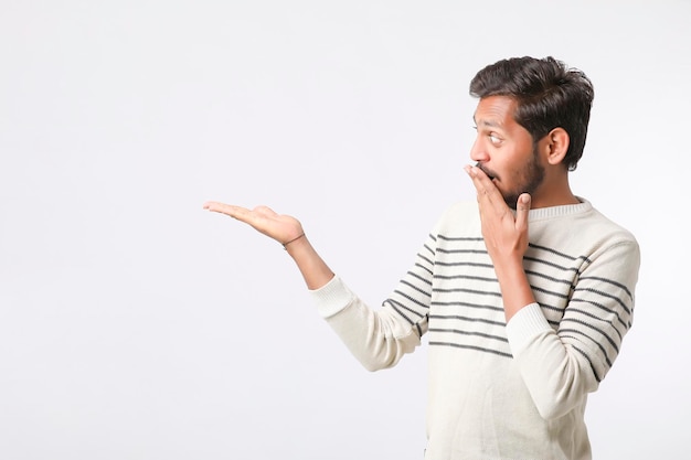 Jeune homme indien donnant l'expression sur fond blanc.