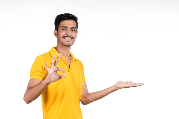 Jeune homme indien montrant l'expression avec la main sur fond blanc