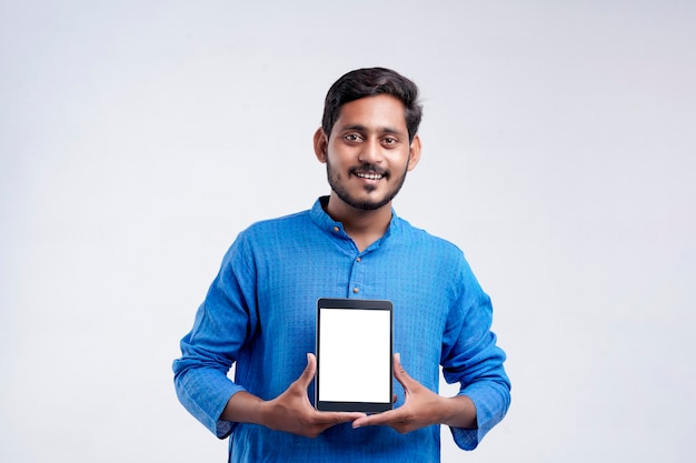 Jeune homme indien montrant la tablette sur fond blanc.