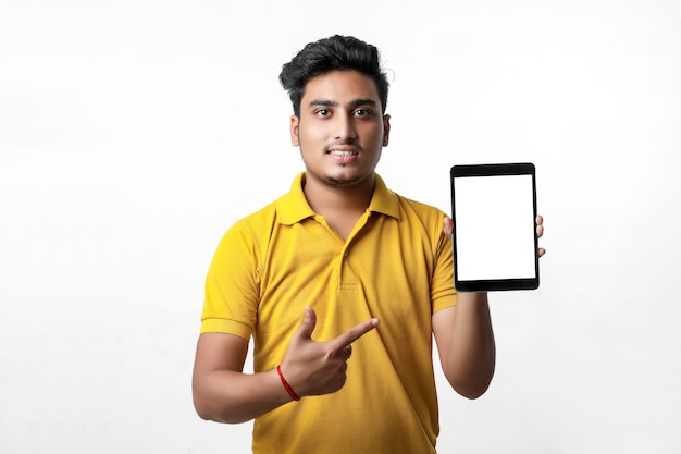 Jeune homme indien montrant la tablette sur fond blanc.