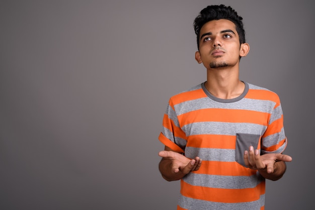 Jeune homme indien sur mur gris