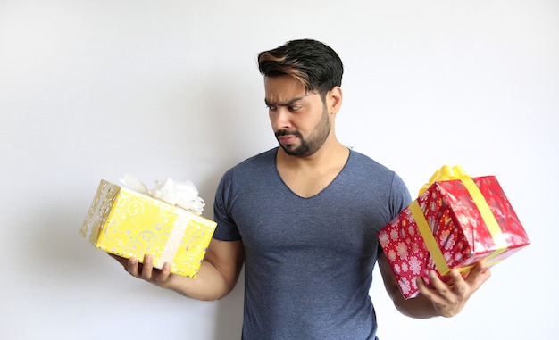 Un jeune homme indien tenant une boîte-cadeau, noël, saint valentin, anniversaire, concept de bonheur