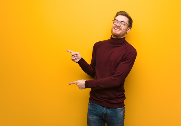 Jeune homme intelligent pointant vers le côté avec le doigt