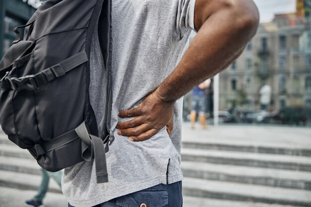 Jeune homme international portant des vêtements confortables en marchant dans le centre-ville