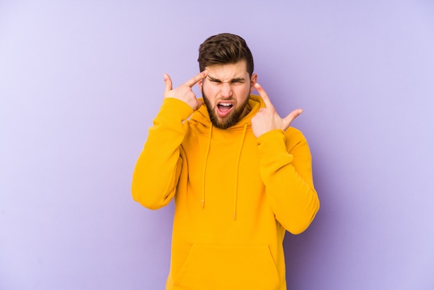 Jeune homme isolé sur fond violet montrant un geste de déception avec l'index.