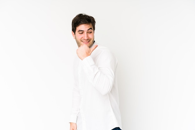 Jeune homme isolé sur des points blancs avec le pouce, riant et insouciant.