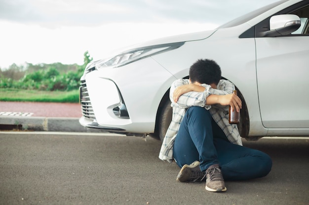 Jeune homme ivre buvant une bouteille de bière ou d'alcool pendant la conduite dangereuse de la voiture Ne pas boire et conduire le concept Ne pas boire et conduire le concept Image sur l'insouciance de l'accident