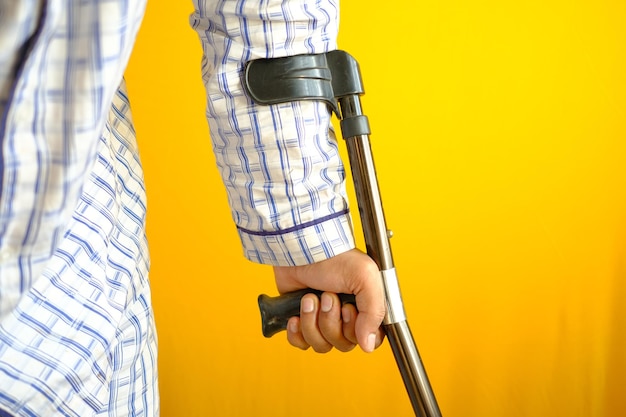 Jeune homme avec une jambe cassée sur des béquilles