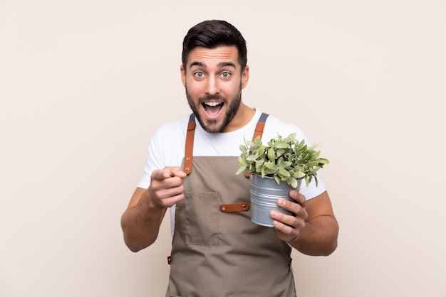 Jeune homme jardinier sur mur isolé