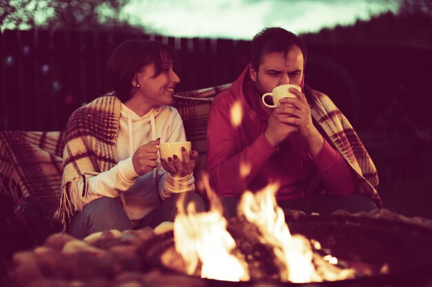 Photo un jeune homme et une jeune femme boivent des verres à l'extérieur.