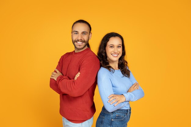 Un jeune homme et une jeune femme confiants, dos à dos.