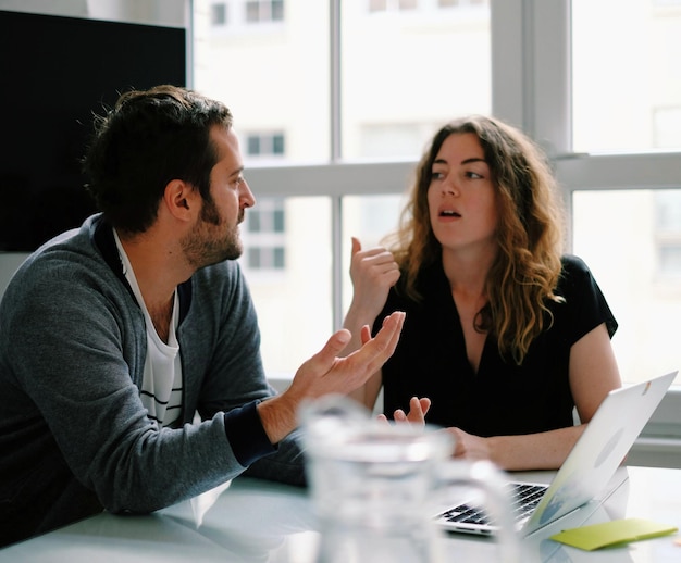 Un jeune homme et une jeune femme se disputent au bureau.