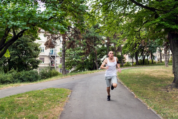 Jeune homme jogging dans le parc. Mode de vie sain.