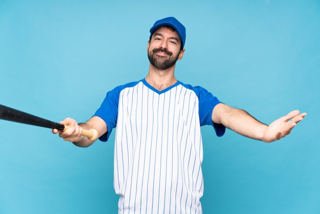 Jeune homme jouant au baseball présentant et invitant à venir avec la main