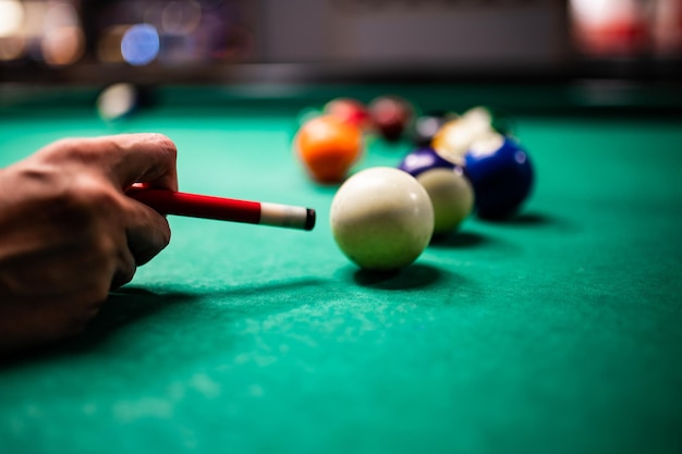 Jeune homme jouant au billard visant un bon coup