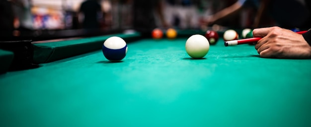 Jeune homme jouant au billard visant un bon coup