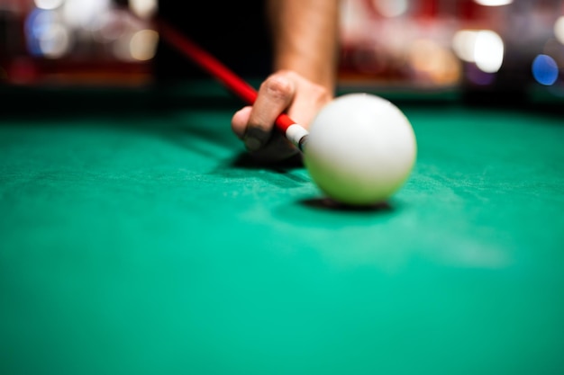 Jeune homme jouant au billard visant un bon coup