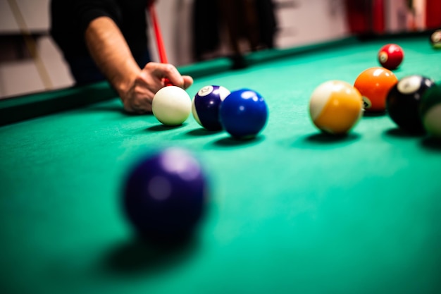 Jeune homme jouant au billard visant un bon coup